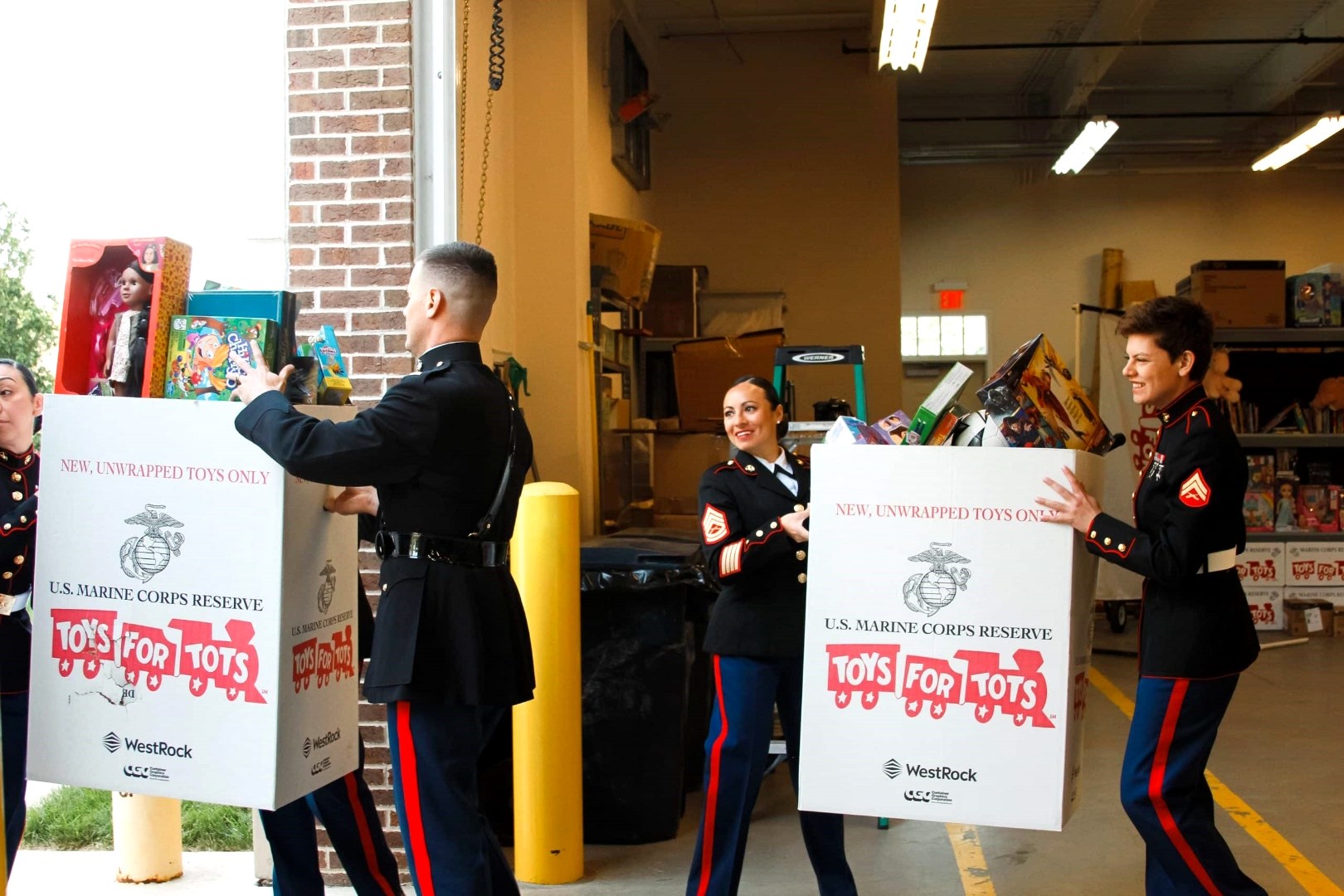 Marines in dress blues unloading Toys for Tots donation boxes