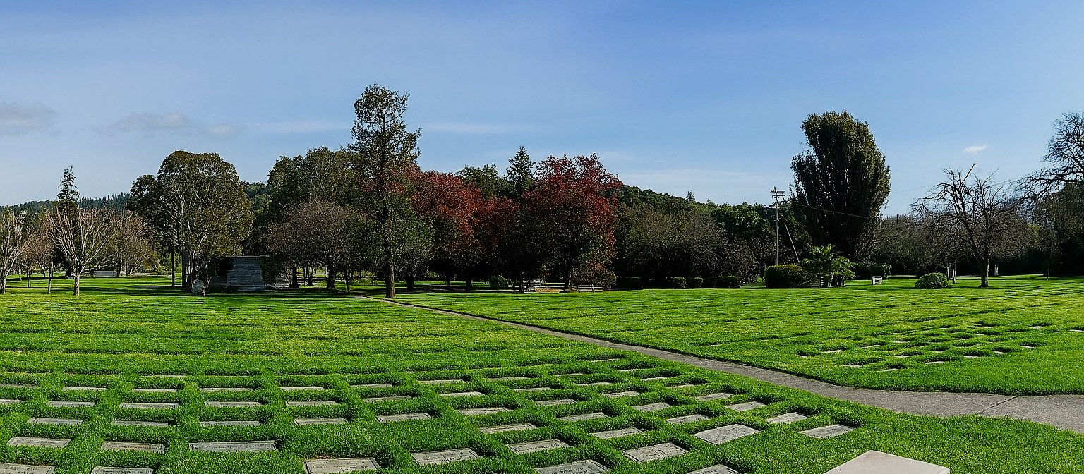 Peaceful view of Santa Rosa Memorial Park grounds with trees and sky